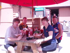 Team TravelCountry.com/Tango sit at a picnic table eating dinner during a training weekend