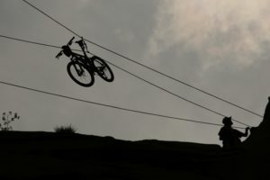 A mountain bike travels down a zipline by itself