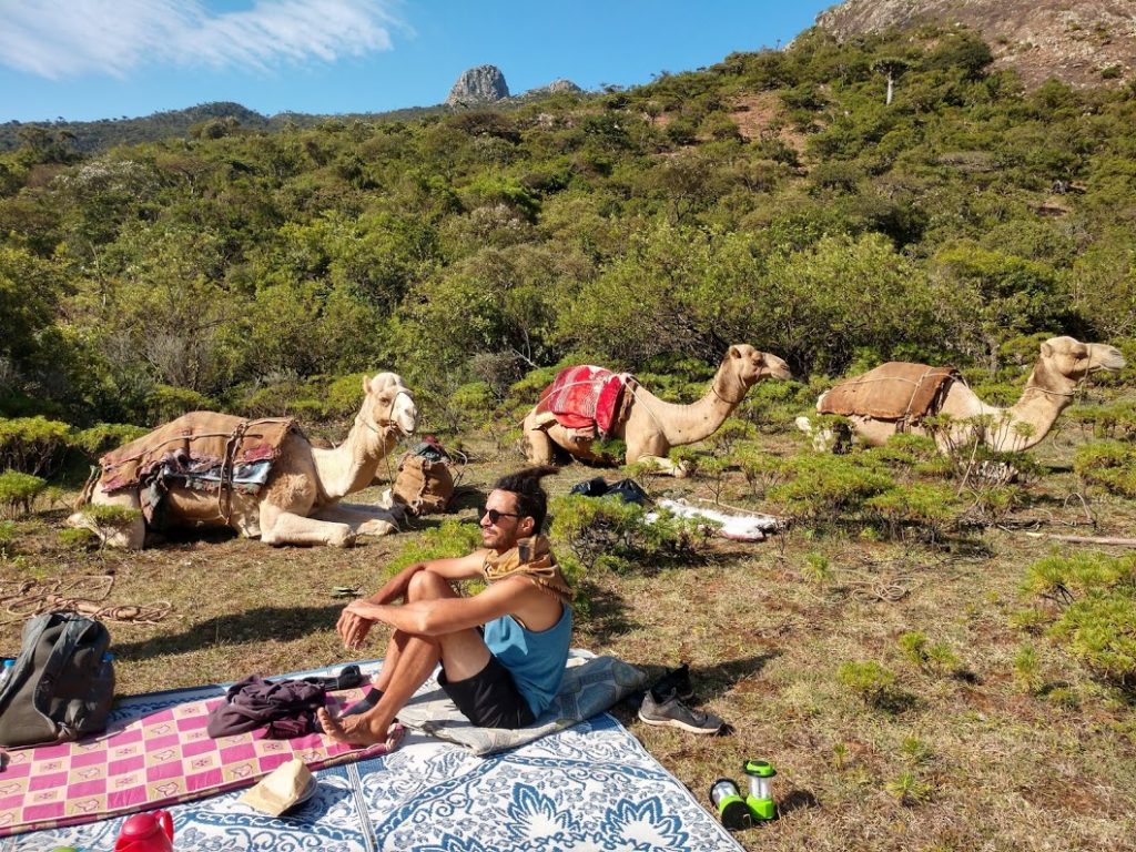 Alex sitting with camels in our campsite